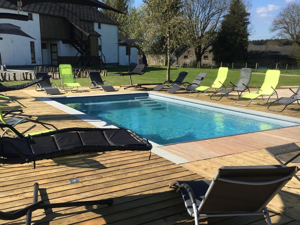 a swimming pool with lounge chairs and a deck at Spacious Holiday Home La Roche en Ardenne with Pool in Beausaint