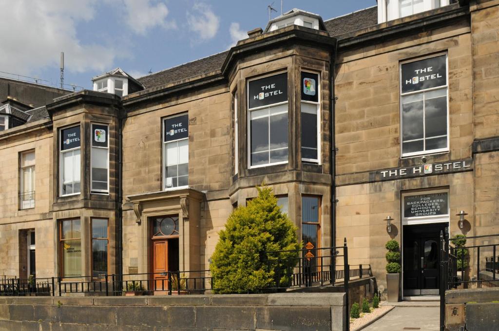 un grande edificio in mattoni con un albero di fronte di The Hostel a Edimburgo