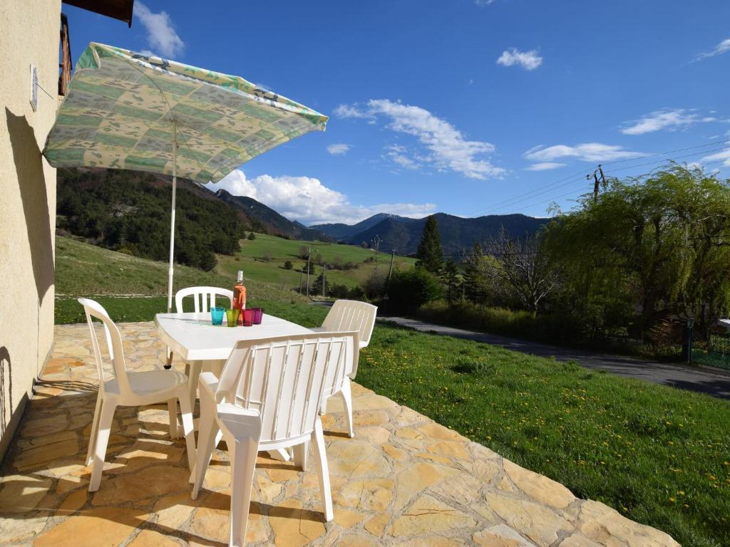 - une table et des chaises sous un parasol sur la terrasse dans l'établissement Apartment with mountain views, à Lus-la-Croix-Haute