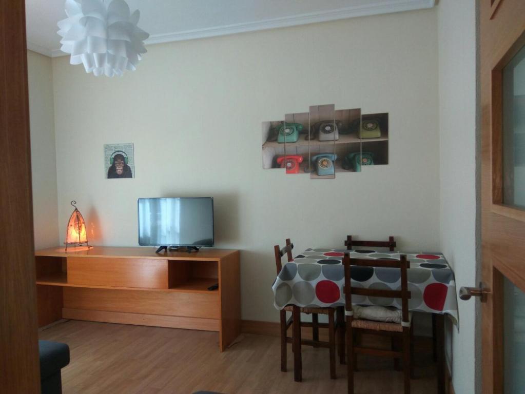 Zimmer mit einem Tisch und einem Schreibtisch mit einem TV in der Unterkunft Betiko in Vitoria-Gasteiz
