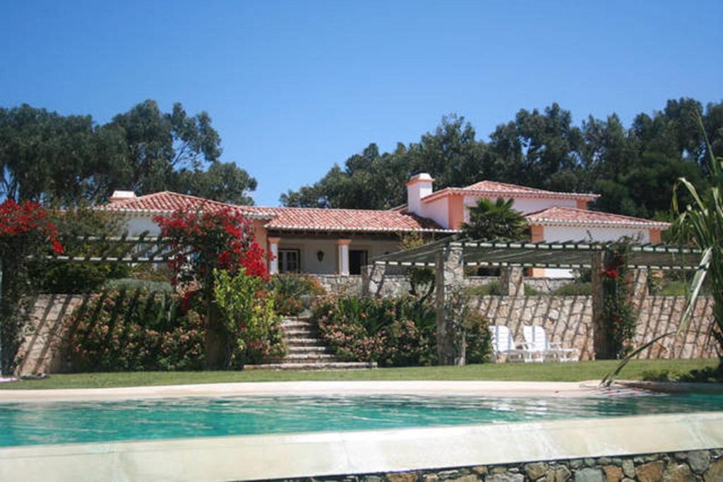 a house with a swimming pool in front of it at Villa Malveira in Alcabideche