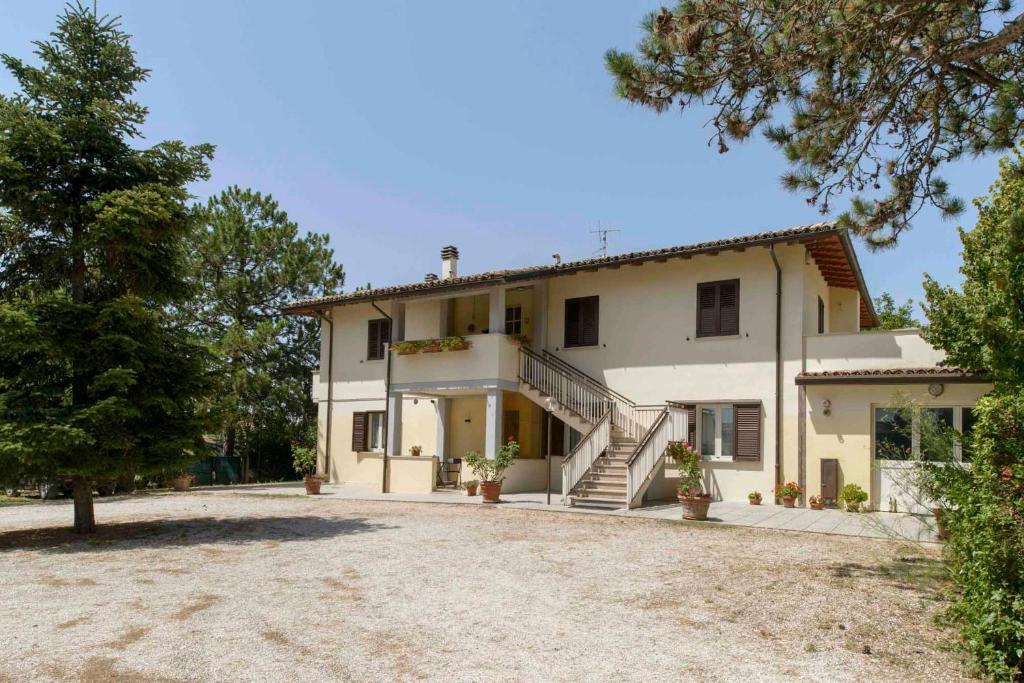 a large white house with a large driveway at La Casa dei Pini in Gubbio