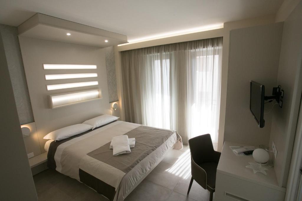 um quarto com uma cama, uma secretária e uma janela em B&B Chez Moi em Tropea