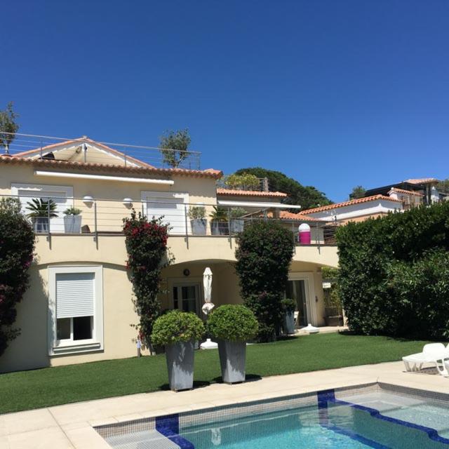 une grande maison avec une piscine devant dans l'établissement Sainte Maxime Studio 2, à Sainte-Maxime