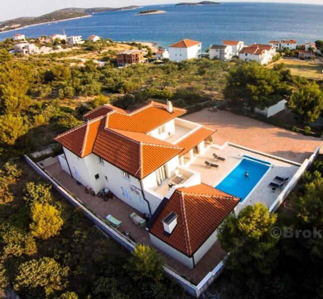 an aerial view of a house with a swimming pool at Villa Lanterna in Rogoznica