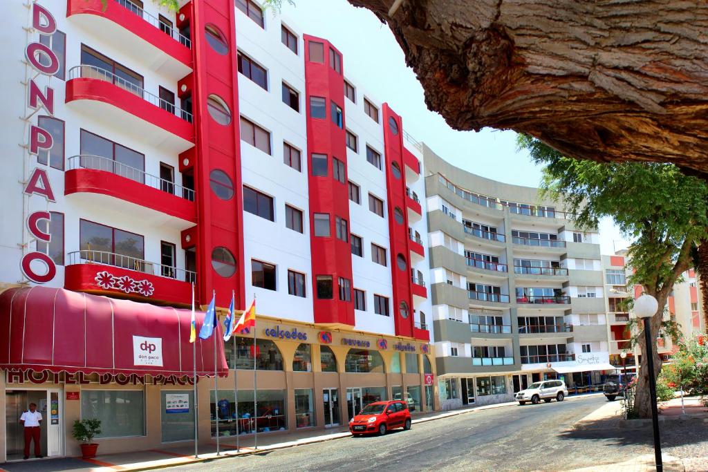 un edificio rojo y blanco en una calle de la ciudad en Hotel LIVVO Don Paco en Mindelo