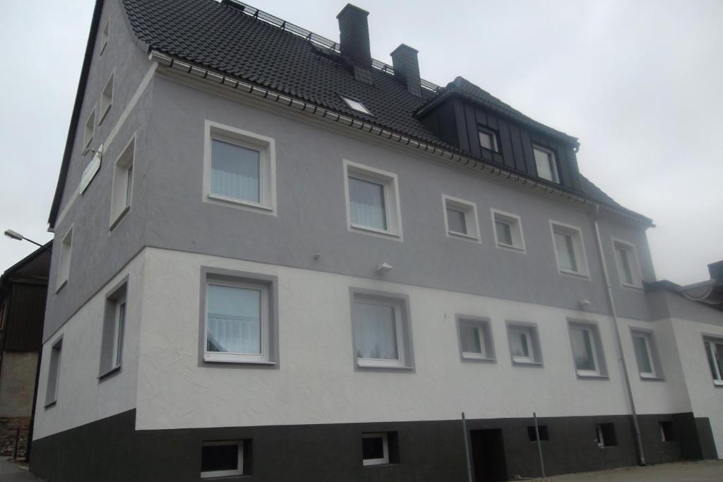 a tall white building with a black roof at Haus Florian in Kurort Oberwiesenthal