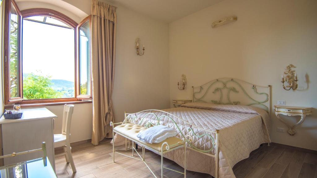 ein Schlafzimmer mit einem Bett und einem großen Fenster in der Unterkunft Il FEUDO in San Gimignano