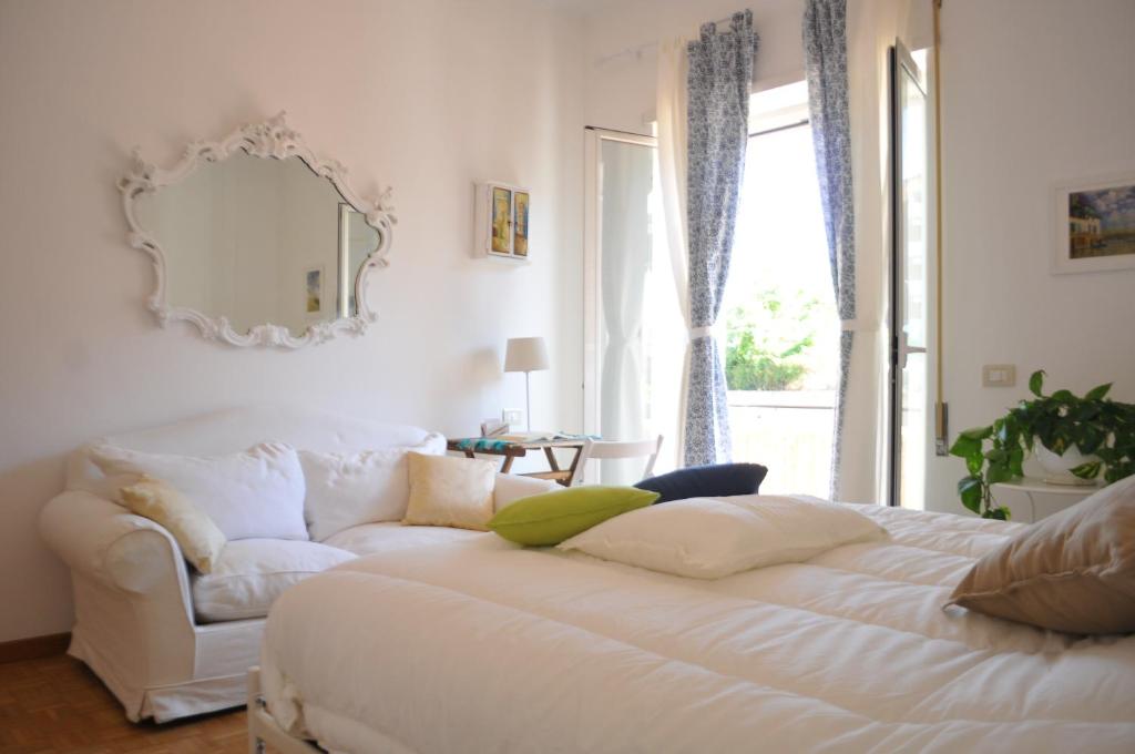 a bedroom with a white bed and a chair and a mirror at Rome Guest Hospitality in Rome