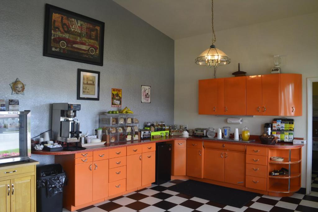 uma cozinha com armários laranja e um piso xadrez em Retro Inn at Mesa Verde em Cortez