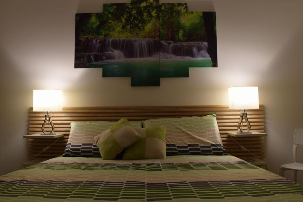 a bedroom with a bed with two lamps on it at suite the natural color in Selargius