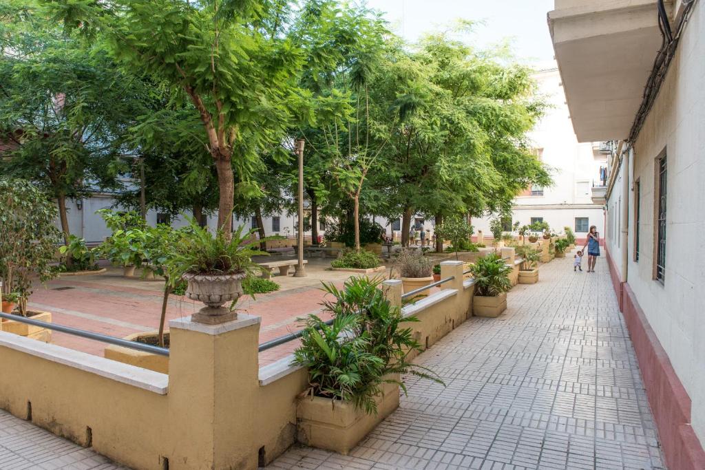 a walkway with potted trees on the side of a building at Apartamento cerca de la Playa y el Centro in Valencia