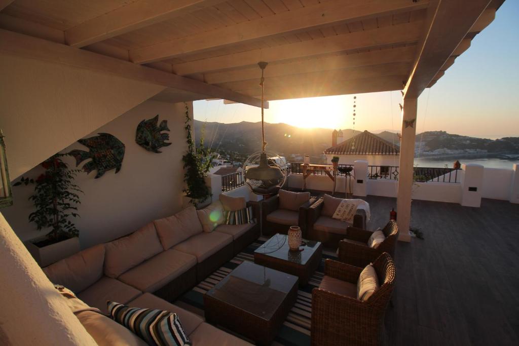 un patio all'ultimo piano con divani, tavoli e il tramonto di Casa Altos 39 a La Herradura