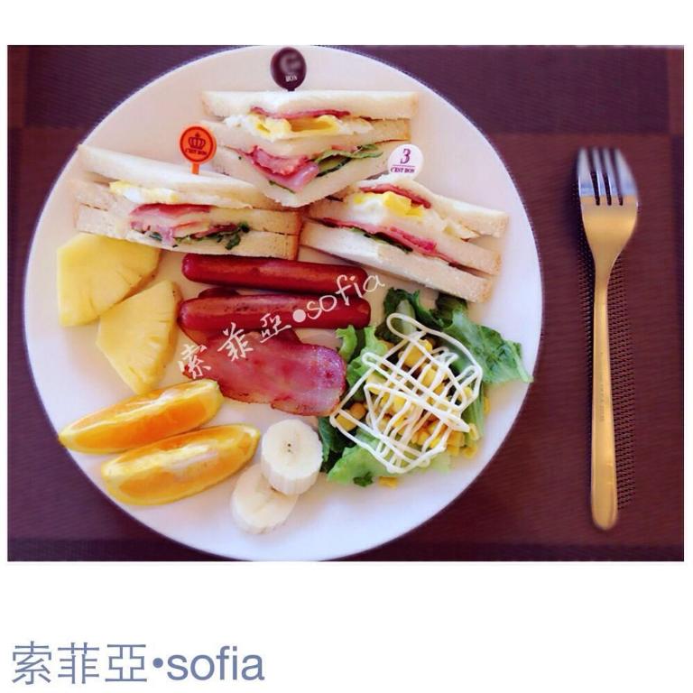 a plate of food with sandwiches and fruit and a fork at Sophia B&amp;B in Dongshan