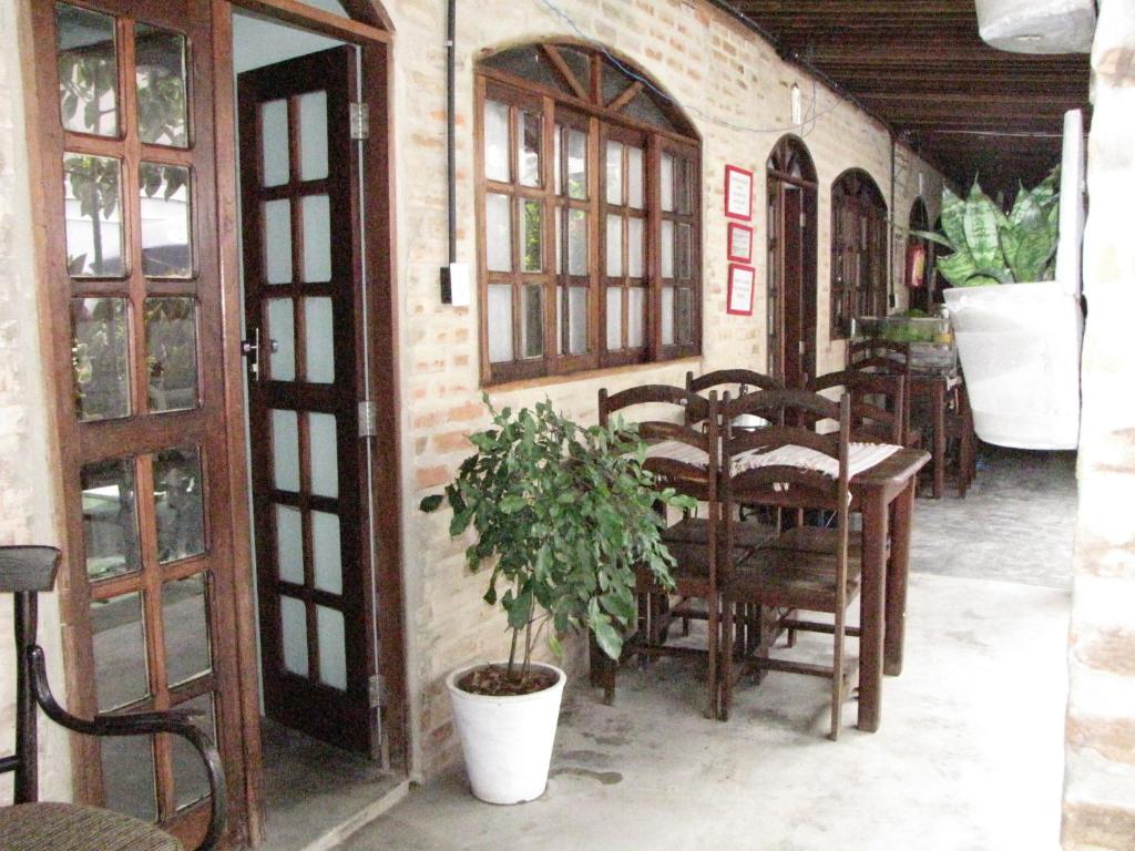 a dining room with a table and chairs and a plant at Pousada Joãozinho Caminhador in Recife