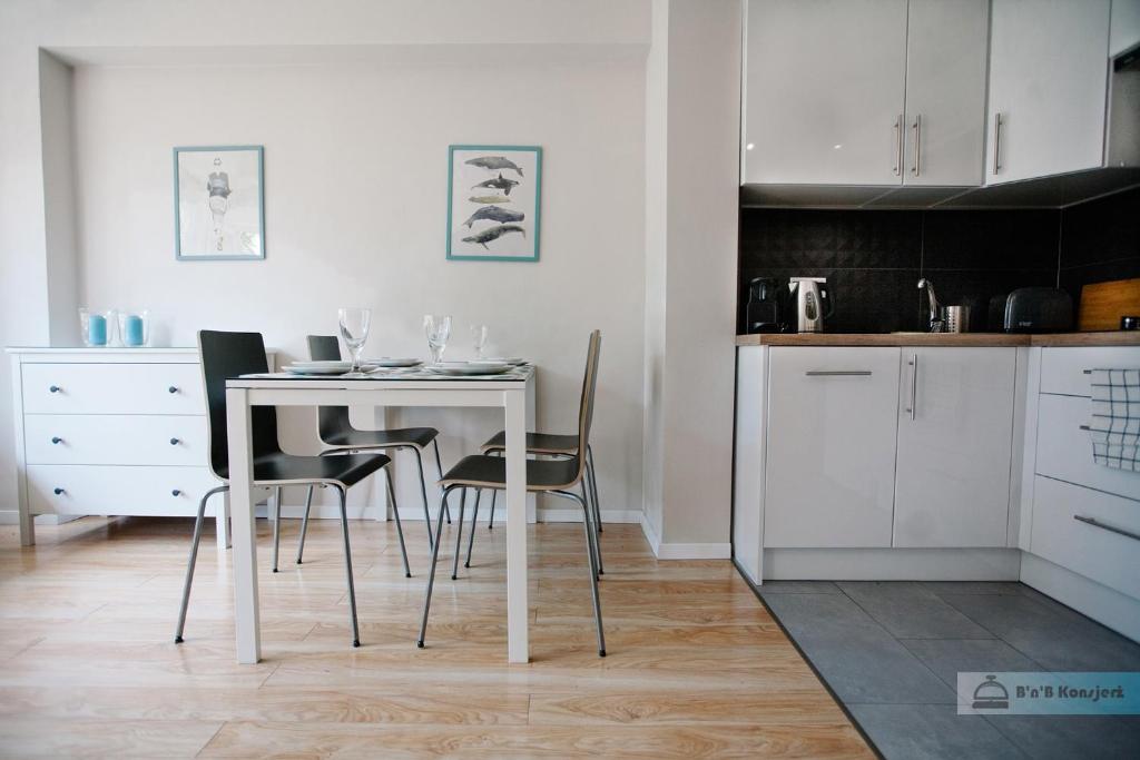 ワルシャワにあるWarsaw Concierge Polin Apartmentのキッチン(白いテーブル、椅子付)