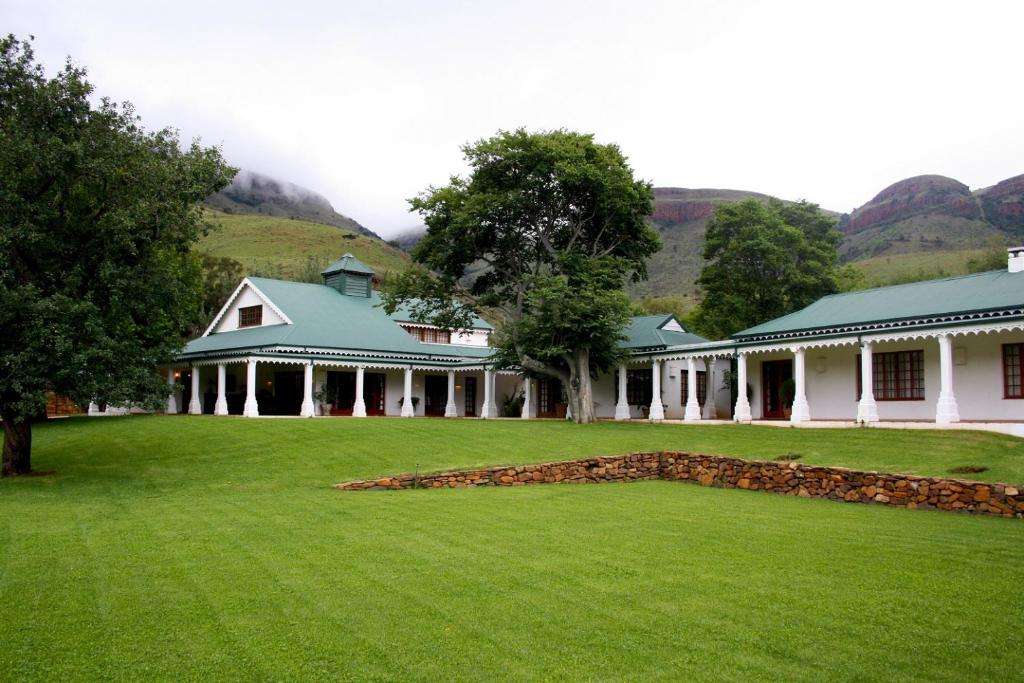 a large house with a green lawn in front of it at Nooitgedacht Trout Lodge in Lydenburg