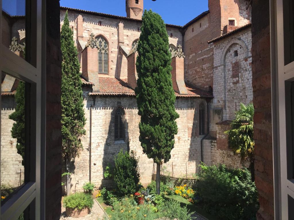 a window view of a building with a garden at L'appart du Cloitre in Albi
