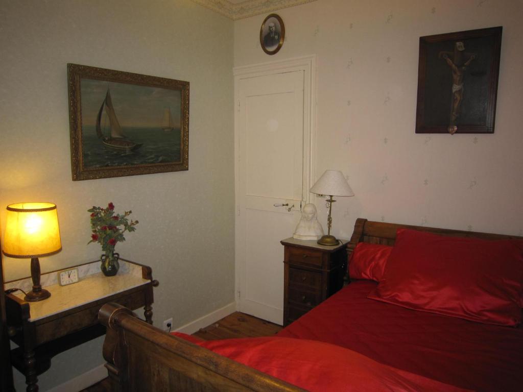 a bedroom with a bed and a table with a lamp at La Maison de Mireille in Le Puy-en-Velay