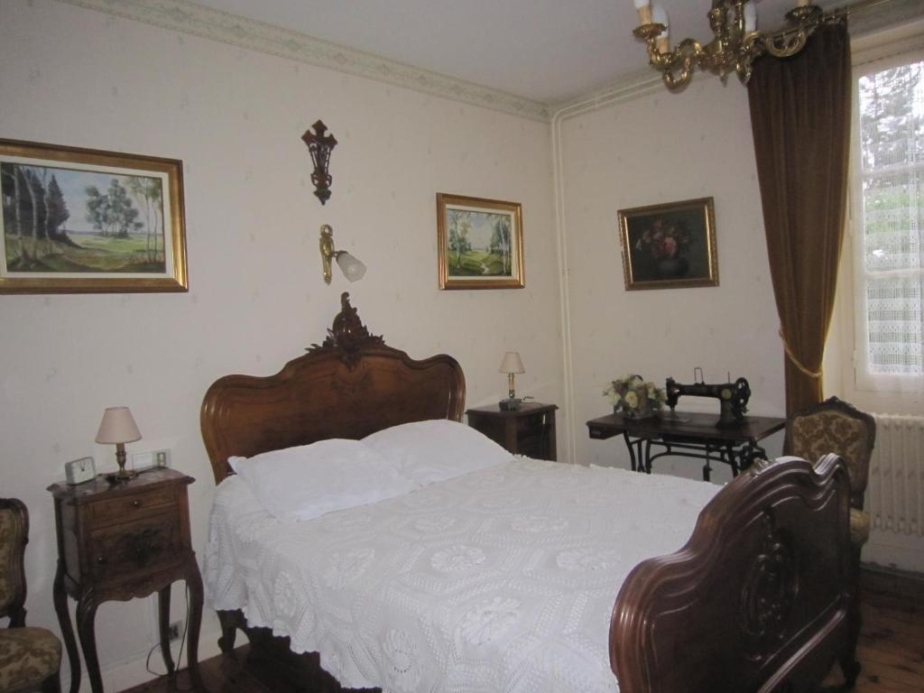 a bedroom with a bed and two chairs and a window at La Maison de Mireille in Le Puy-en-Velay