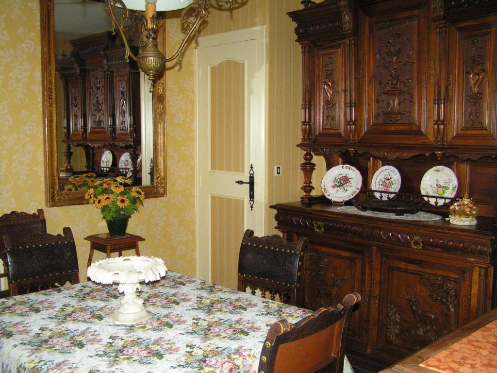 a dining room with a table and plates on a wall at La Maison de Mireille in Le Puy-en-Velay