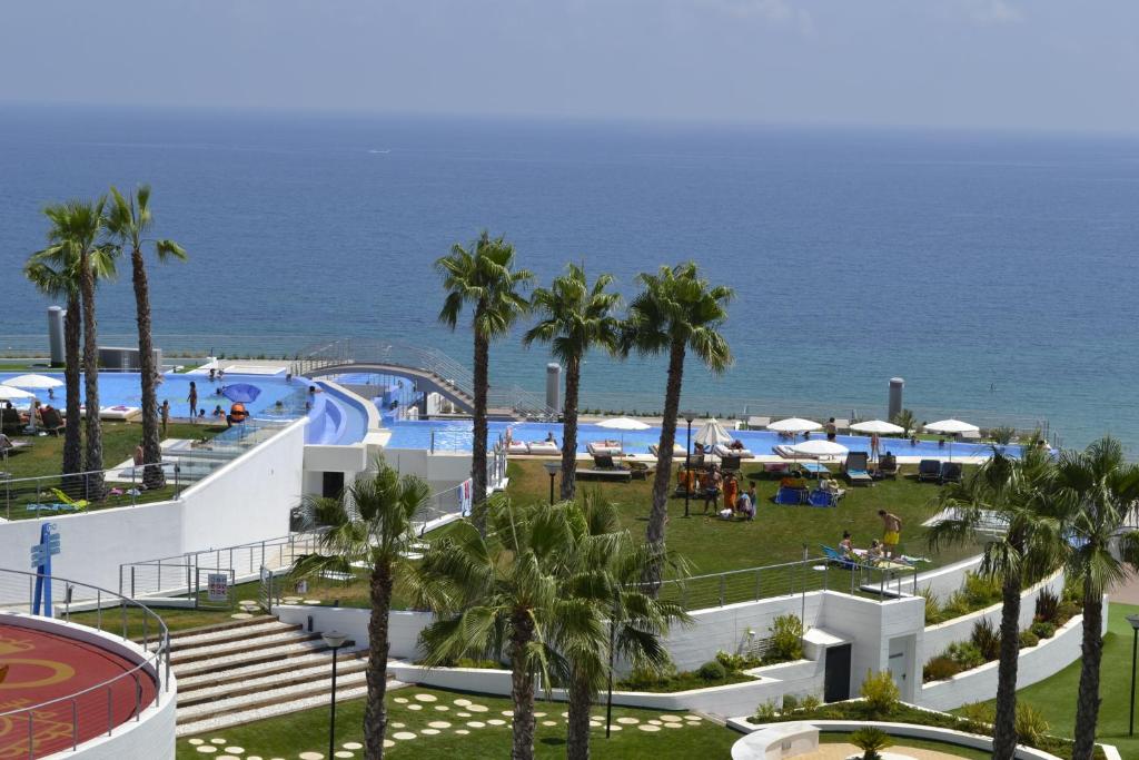 Elle offre une vue sur la piscine bordée de palmiers et l'océan. dans l'établissement Amazing Infinity View Apartment, à Arenales del Sol