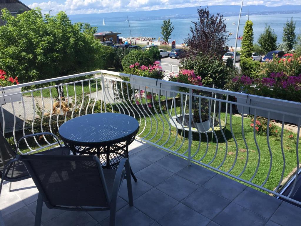 een patio met een tafel en stoelen op een balkon bij villa maxilly in Maxilly-sur-Léman