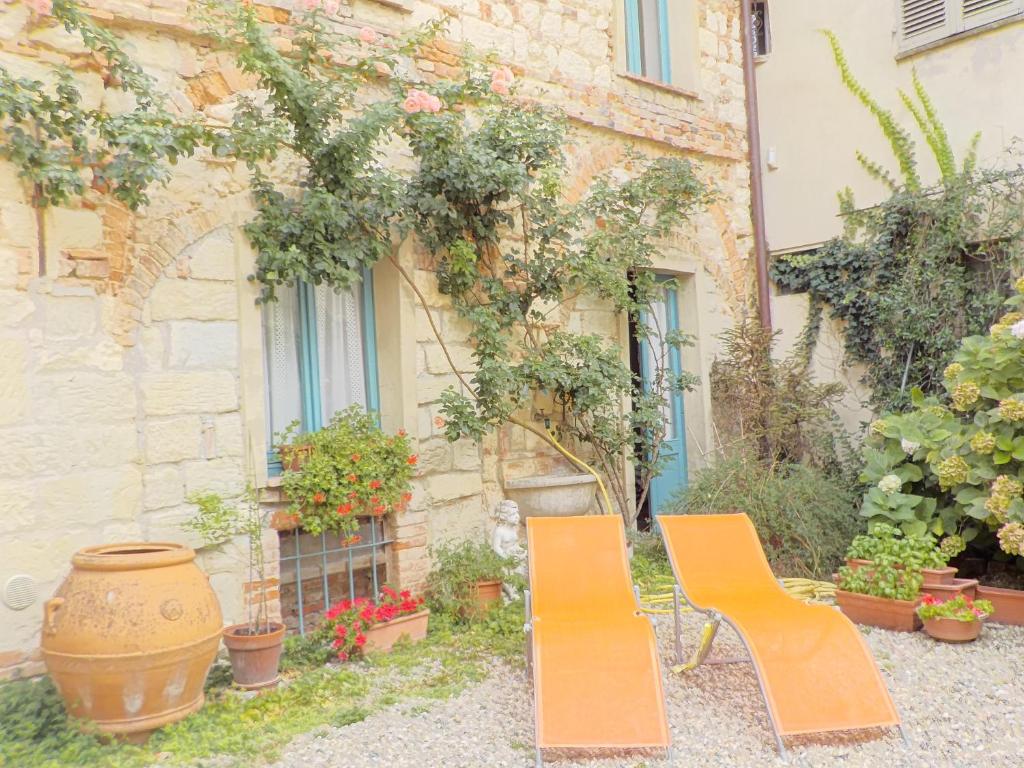 two orange chairs sitting in front of a building at Benvenuti Altrove in Cella Monte