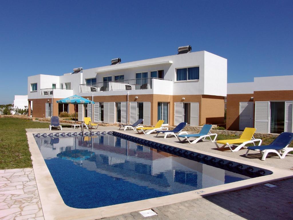 a villa with a swimming pool in front of a house at Apartamentos Maritur in Albufeira