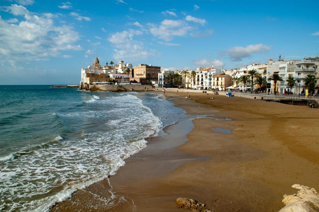 a view of a beach with buildings and the ocean at Apartment Port D'aiguadolç Sitges in Sitges