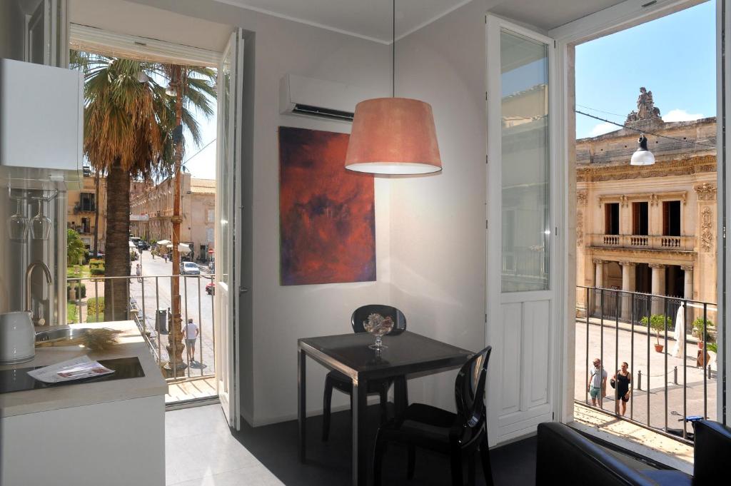 a dining room with a table and a large window at Kalote' Apartments in Noto