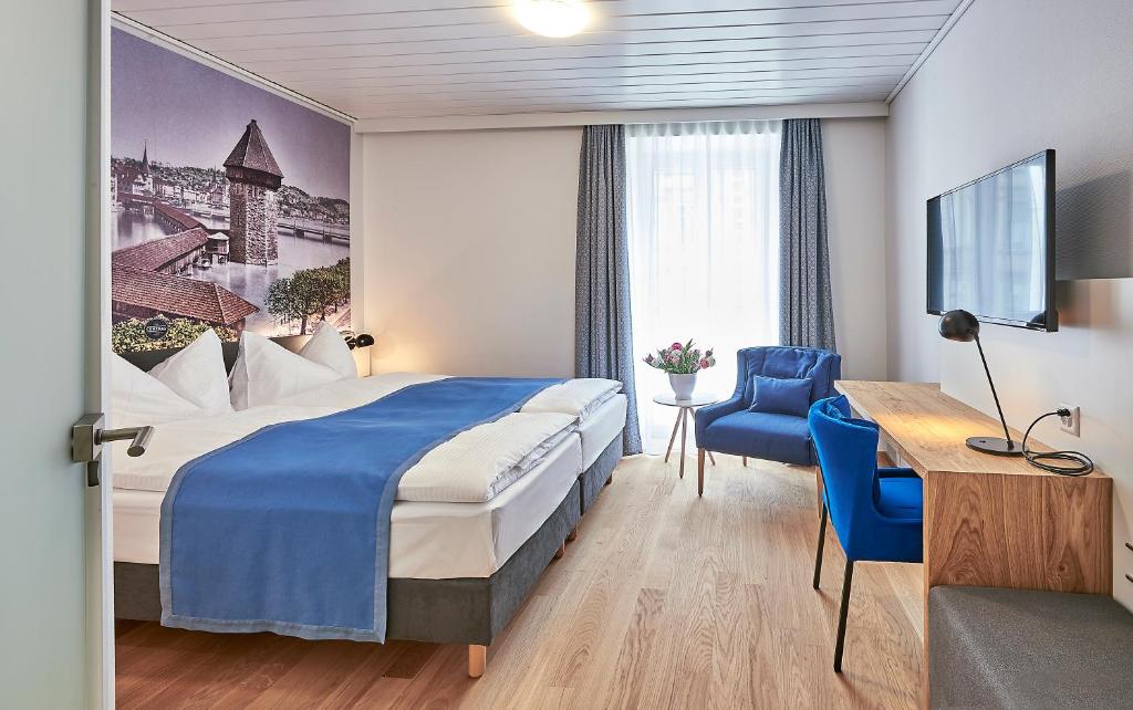 ein Hotelzimmer mit einem Bett und einem Schreibtisch in der Unterkunft Hotel Central Luzern in Luzern