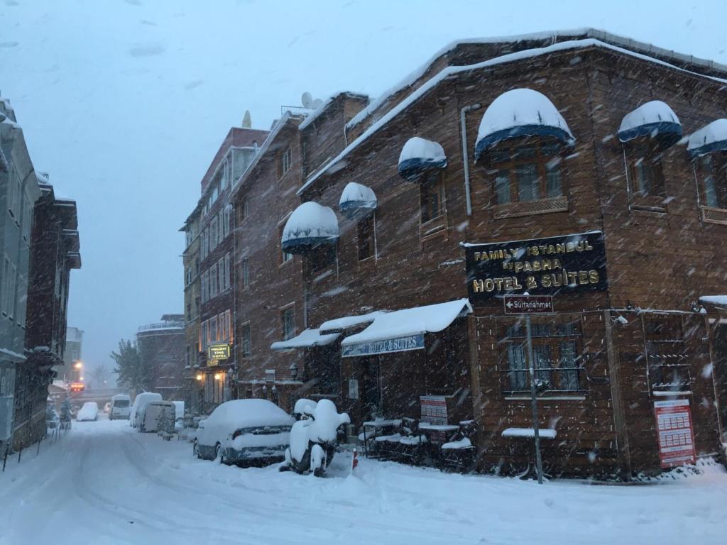 una calle cubierta de nieve con un edificio de ladrillo en Family Istanbul Hotel en Estambul
