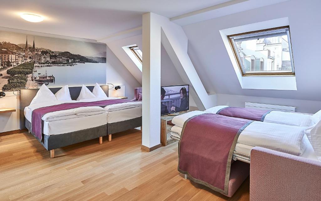 Postel nebo postele na pokoji v ubytování Hotel Central Luzern