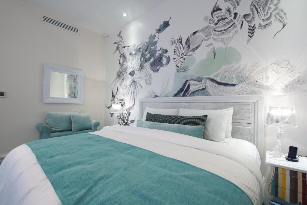 een slaapkamer met een bed met een groene en witte sprei bij 1850 Hotel Boutique in Guanajuato