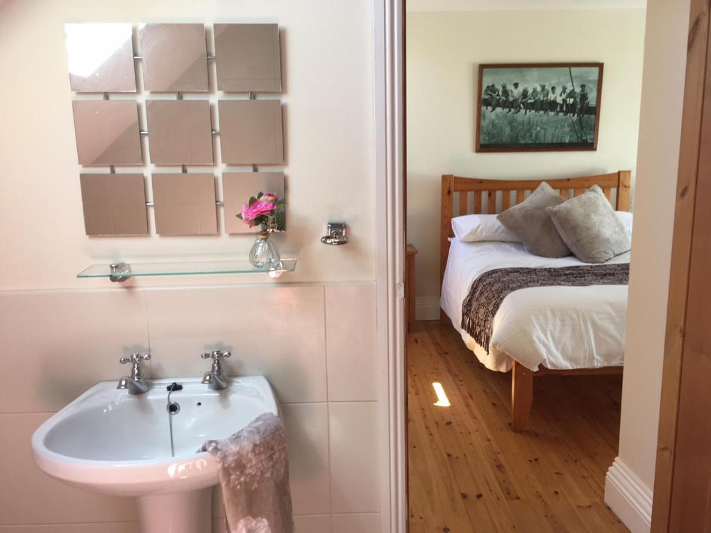 a bathroom with a sink and a bed at Burrowlodge in Kilfenora