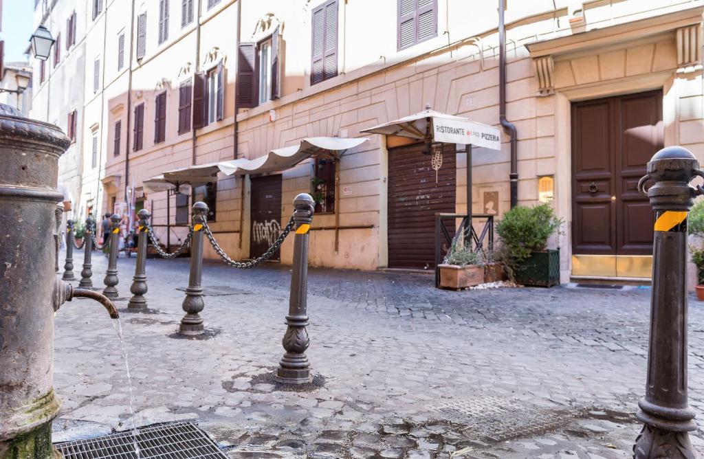 una strada con fila di parchimetri di fronte a un edificio di Studio via di Montegiordano a Roma
