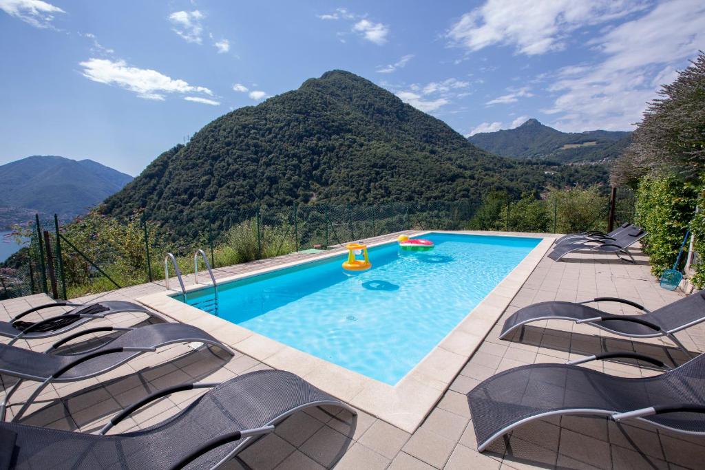 アルジェーニョにあるArgegno Belvedere apprtmentsの山々を背景に椅子付きのスイミングプール