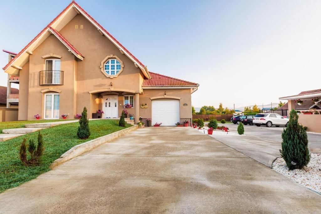 een groot huis met een oprit ervoor bij Casa Iulia in Haţeg