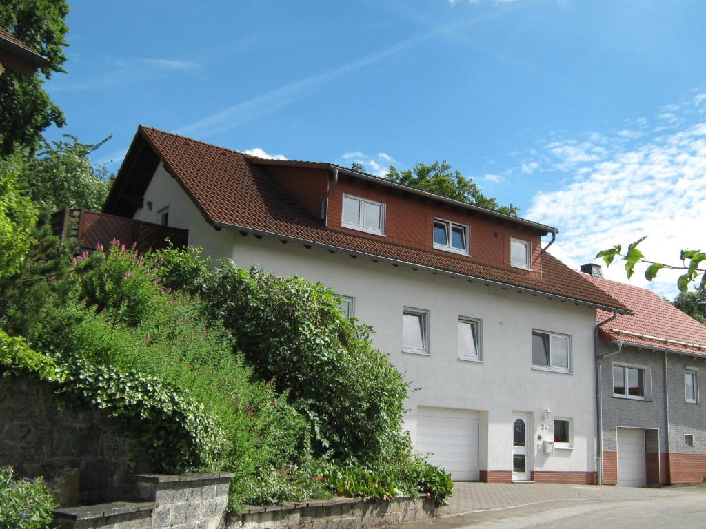 Casa blanca con techo rojo en Ferienwohnung Sauerland Panorama, en Korbach