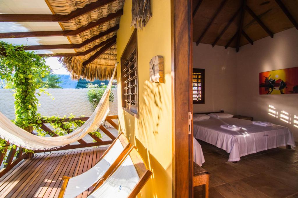 a bedroom with a bed and a hammock in a room at Pousada Vento do Kite in Barra Grande