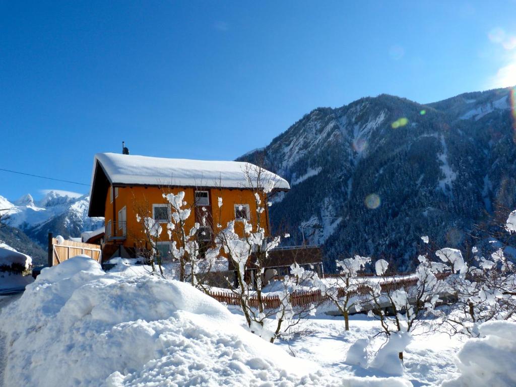 ein schneebedecktes Haus vor einem Berg in der Unterkunft Apart Urban in Kauns