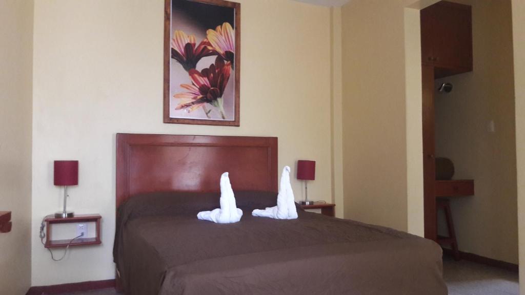 a bedroom with a bed with white towels on it at Hotel Florida Oaxaca in Oaxaca City