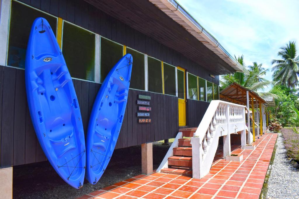 dos tablas de surf azules están en el lado de un edificio en Hotel Nuquimar, en Nuquí