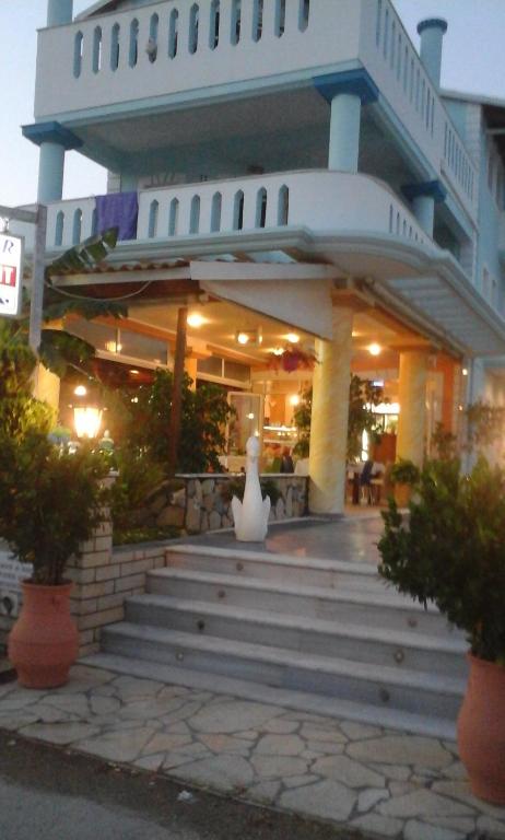 a large building with a white vase on the stairs at Hotel Spiros in Ammoudia