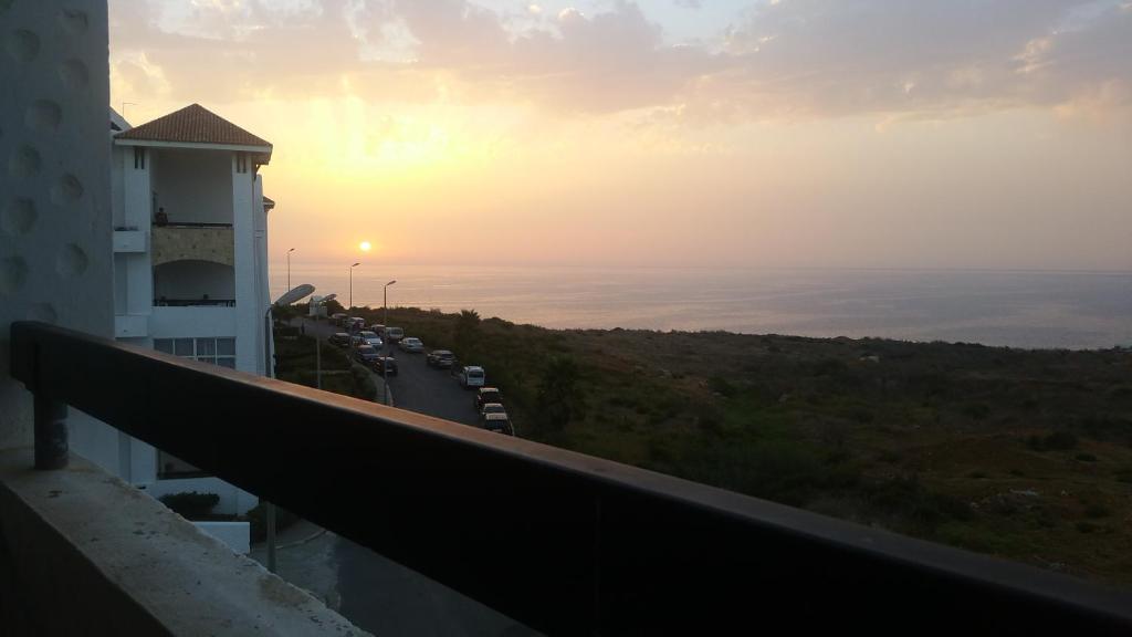 a view of the sunset from the balcony of a building at Asilah marina golf in Asilah