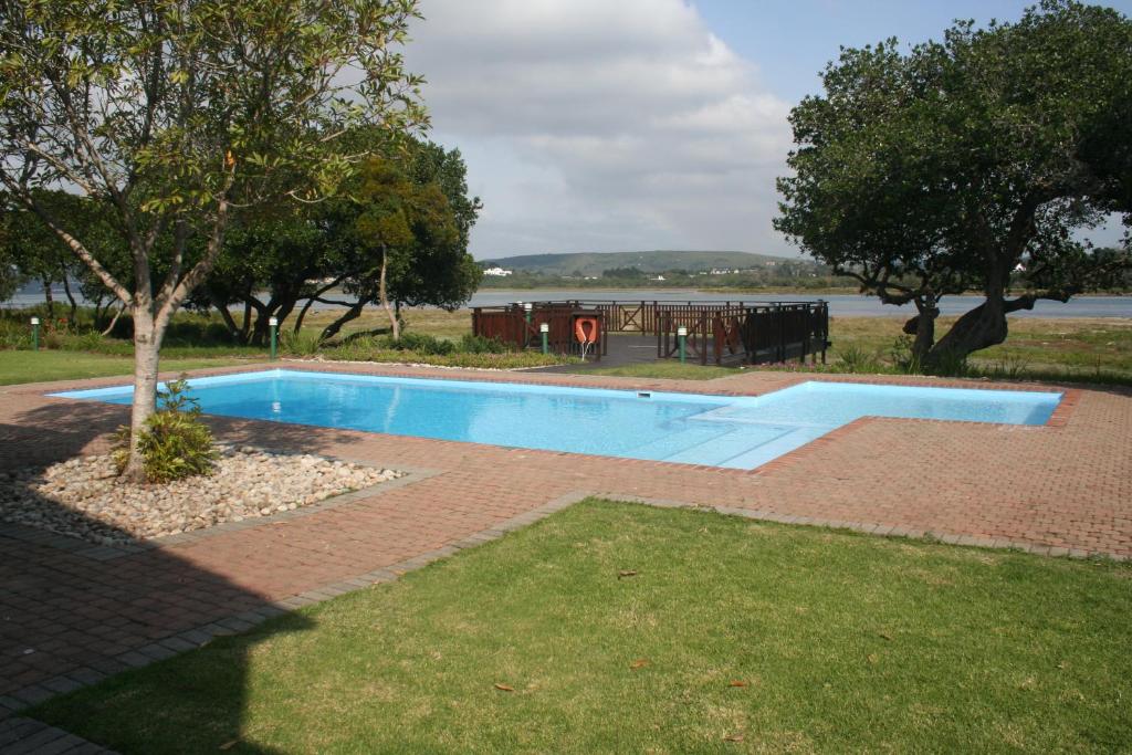 a swimming pool in a yard with a table at Keurbooms River Lodge 21 in Keurboomstrand