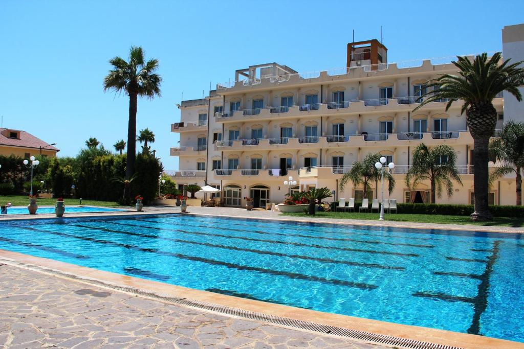 a large swimming pool in front of a building at Club Hotel Kennedy in Roccella Ionica
