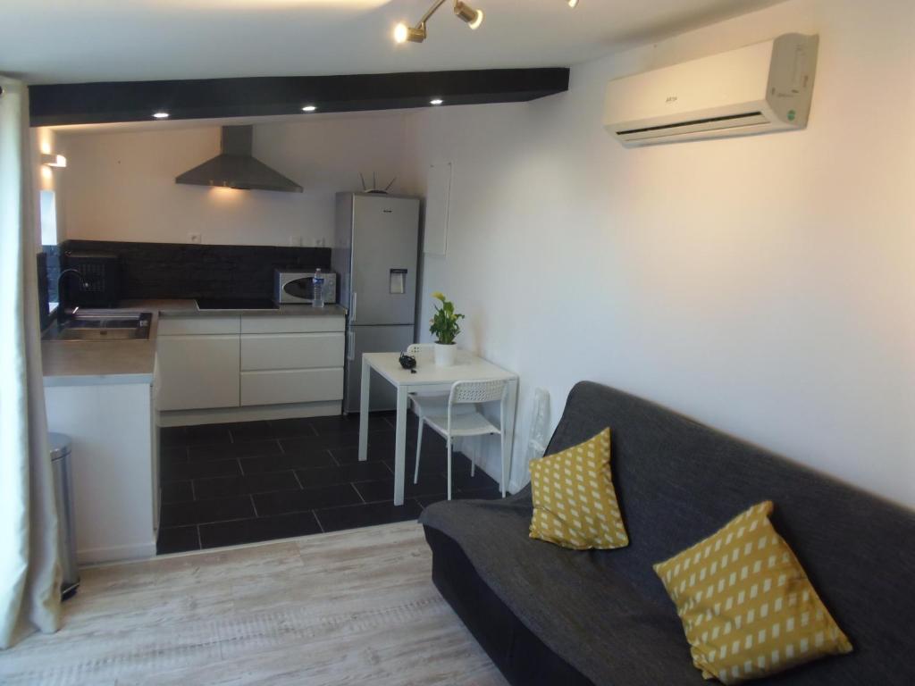 a living room with a couch and a kitchen at Joli Mazet entre Montpellier et Nimes in Aimargues