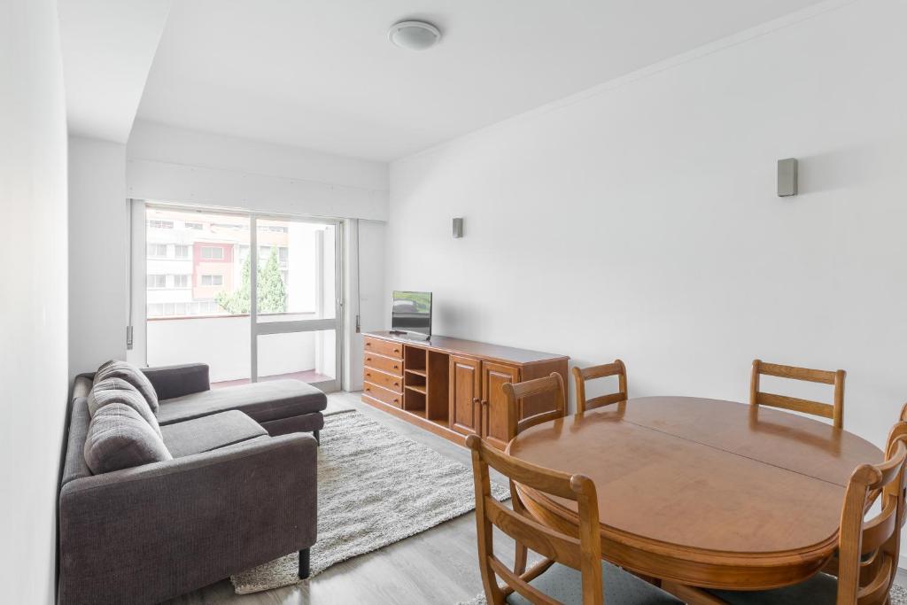 ein Wohnzimmer mit einem Sofa und einem Tisch in der Unterkunft The Perfect Porto Apartment in Porto